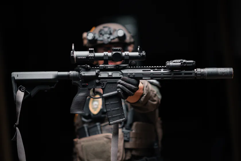Officer in tactical gear holding 5 Tactix 1-10x24 Riton Scope