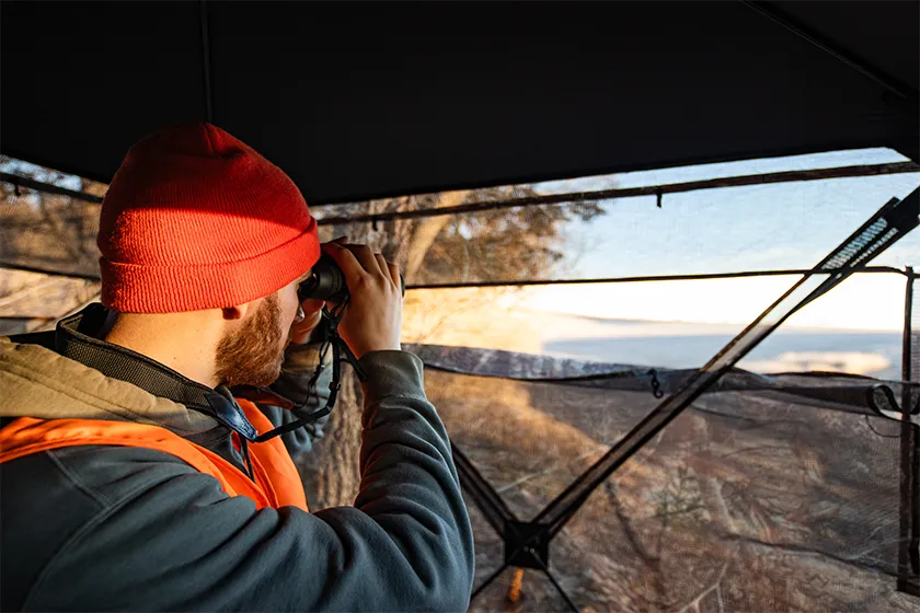 man glassing from a deer blind