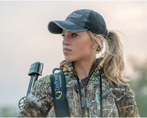 Woman bow hunting looking in the distance
